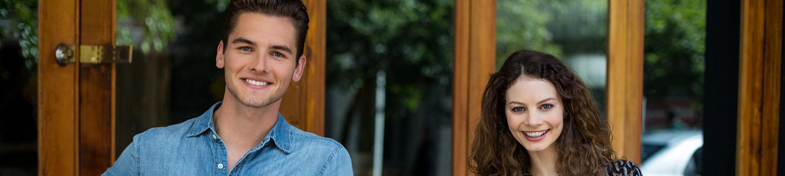 Young woman and man in front of business storefront.