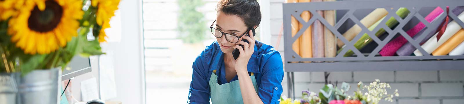 Woman on phone working in flower shop.